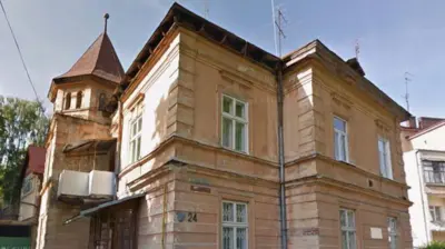 Будинок з двома поверхами, коричневі стіни, добудований зліва балкон