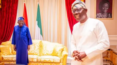 Presdient Tinubu in blue outfit smiling wit Sanwo-Olu on white outfit