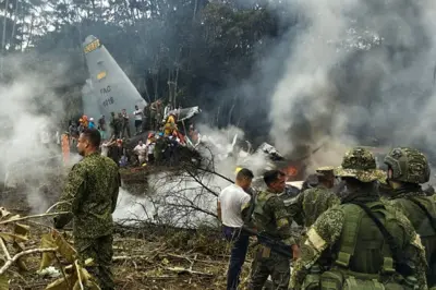 This screen grab shows soldiers and rescuers near an Air Force Hercules emitting thick smoke after the aircraft crashed during takeoff in Puerto Leguizamo, Colombia, near the southern border with Ecuador, on March 23, 2026. 