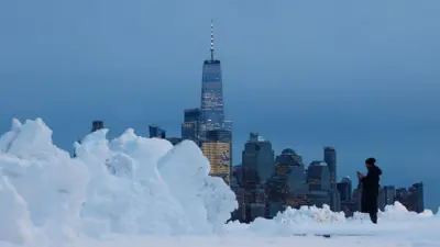 New York'taki Dünya Ticaret Merkezi binası önünde dev kar yığınlarının yanında küçük kalmış bir adam