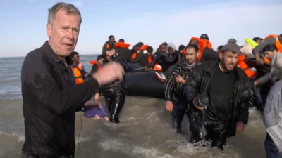 El corresponsal de la BBC, Andrew Harding, entre el agua presenciando el bote de migrantes agujerado por la policía francesa