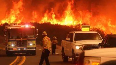 Fire personnel gather to fight the Airport Fire as it gains ground near Lake Elsinore, California, on 10 September 2024