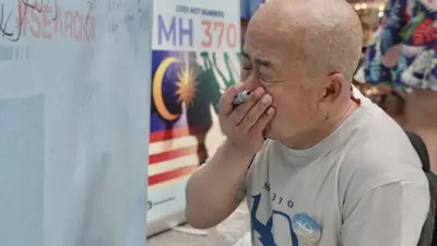 Li Eryou weeps after as he writes a message to his missing son