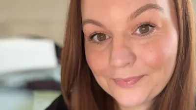 A selfie of Symone, who has brown hair and brown eyes and is smiling at the camera.
