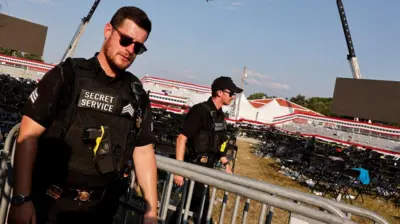 No primeiro plano um agente, vestindo uniforme preto e armado, ao ladoslot loveuma gradeslot loveproteção. No fundo, outro agente e mais ao fundo, cadeiras e uma arquibancada vazias.