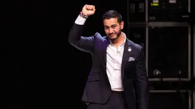 عبدل سید مشتش را به علامت پیروزی بالا برده است