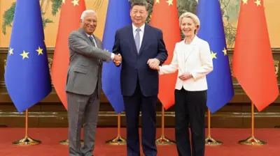 2025年7月24日，中国国家主席习近平（中）在北京人民大会堂与欧洲理事会主席安东尼奥·科斯塔及欧盟委员会主席乌尔苏拉·冯德莱恩握手。三人身后是一排欧盟与中国的国旗。