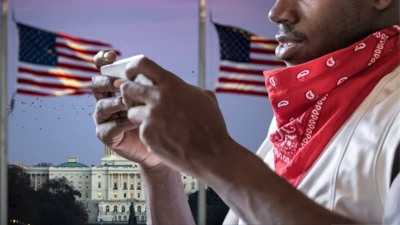 Man hold phone wit US flag at di back