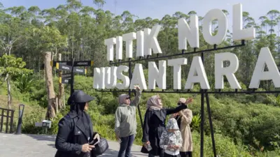 Sekelompok pengunjung berfoto di depan papan bertulisan Titik Nol Nusantara, Ibu Kota Nusantara (IKN), Kalimantan Timur.