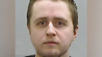 A police-issued photograph of Alexander McCartney - he is looking directly into the camera, and has short brown hair.