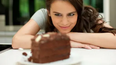 Perempuan ini menatap sepotong kue dengan penuh perhatian