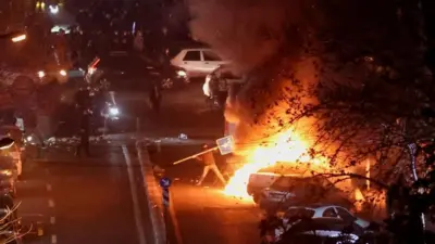 テヘランの夜の道に集まり抗議する人たち
