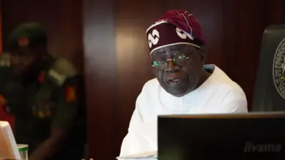 Aarẹ Tinubu pẹlu aṣọ funfun ati fila idanimọ rẹ