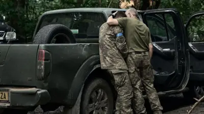 A Ukrainian soldier comforts a comrade during fighting in Kursk