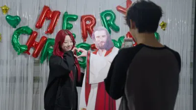 예수 등신대를 두고 손하트 사진을 찍고 있는 여성이 있다