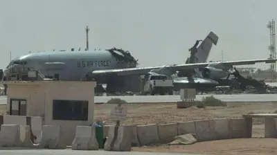 Uma grande aeronave cinza, com identificação da Força Aérea dos Estados Unidos, aparece com parte faltando e a cauda inclinada