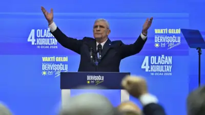 Müsavat Dervişoğlu mavi zemin üzerine partisinin amblemi ve 4. olağan genel kurultay yazısı ile kürsüde kollarını iki yana kaldırmış halde salonu selamlıyor