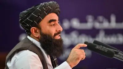 ذبیح‌الله مجاهد، سخنگوی حکومت طالبان هنگام صحبت در یک نشست خبری