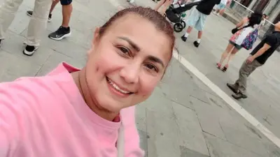 Yulixa Tolosa con un saco rosa mira sonriente a la cámara