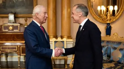 Britain's King Charles III (L) shakes hands as he welcomes Canada's Prime Minister Mark Carney ahead of an audience at Buckingham Palace, in central London, on March 17, 2025. 