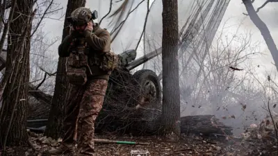 Украинский военный стреляет из гаубицы