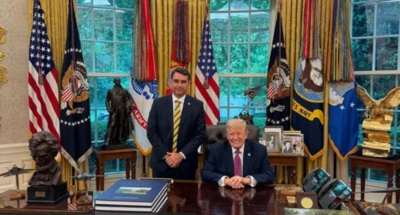 Flávio Bolsonaro e Donald Trump sorrindo em foto oficial no Salão Oval
