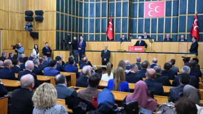 Bahçeli MHP grup toplantısında kürsüde, onu izleyen MHP'liler arkadan görünüyor. 