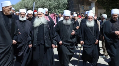 رهبران روحانی یک فرقه مذهبی با کلاهی سفید و لباس‌های مخصوص مذهبی سیاه رنگ