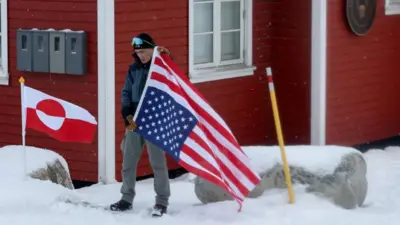 Osoba, która nie chciała podać swojego nazwiska, protestuje przed Konsulatem Amerykańskim przeciwko – jak twierdzi – „zagrożeniu możliwością aneksji Grenlandii przez USA”, 14 marca 2025 roku w Nuuk, Grenlandia. Prezydent USA Donald Trump wielokrotnie zapowiadał przejęcie Grenlandii przez Stany Zjednoczone.