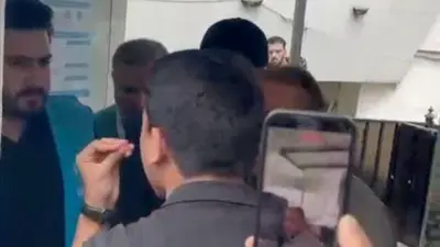 یک پناهجوی افغان در حال صحبت با یکی از کارمناان نمایندگی ملل متحد در امور مهاجرین در عراق است. او ناراحت به نظر می‌رسد و در حال توضیح دادن به این کارمند است که به او اجازه بدهد که وارد ساختمان نمایندگی شود. 