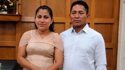Glendy González de la Cruz e Nixon Pérez Paz posam juntos, sorridentes, diante de um altar em uma igreja