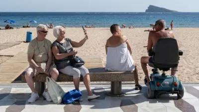 Brytyjscy turyści na plaży w Benidormie.