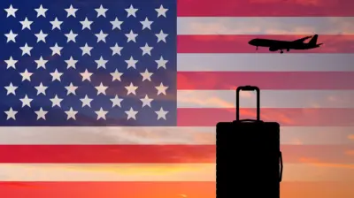 Mala e avião tendo como pano de fundo a bandeira dos EUA 