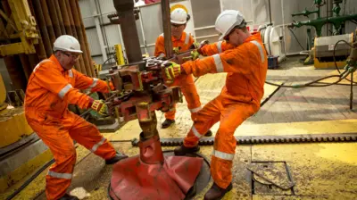 Tres hombres trabajando en la industria petrolera en Noruega