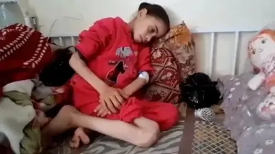 Noora Mohammed sentada encolhida em sofá