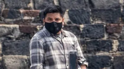 Foto de um homem usando uma máscara preta na boca