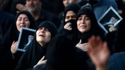 Женщины в черных исламских одеяниях с портреоами Хаменеи скорбят о его смерти на Площади революции в Тегеране, 1 марта 2026 года