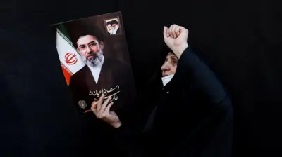 عکس مجتبی خامنه‌ای در دست یک زن هوادار جمهوری اسلامی