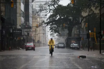 Pessoa andando de bicicleta em meio à chuva