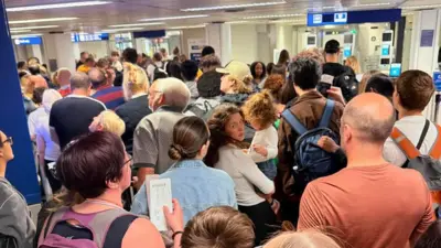 Długa kolejka osób czekających na kontrolę na lotnisku.