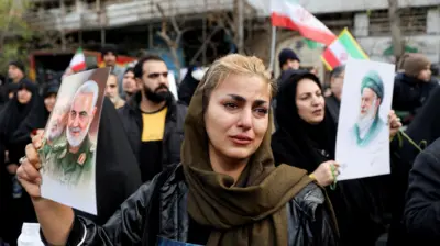 ईरान के प्रदर्शन के दौरान मारे गए सुरक्षाकर्मियों के जनाज़े में पहुंची एक महिला