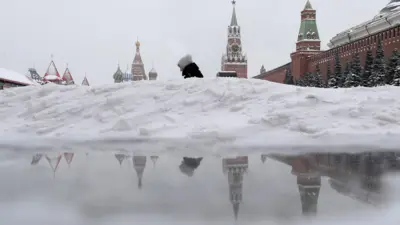 Женщина в сугробах на Красной площади. 22 апреля - Международный день Земли