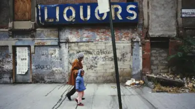 Una mujer pasea con una niña en Harlem, uno de los barrios más pobres de Nueva York
