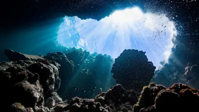 Bubbles, rocks and beams of sunlight beneath the ocean 