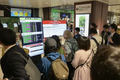 Passageiros observam telas anunciando suspensão de serviço de trens na estação de Sendai, no norte do Japão, nesta segunda-feira (20/04)