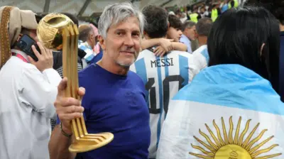 Jorge Messi tras la final del Mundial de Qatar que ganó Argentina, sosteniendo el trofeo al mejor jugador del torneo que le entregaron a Lionel Messi