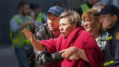 працівники ДСНС тримають жінку в покривалі