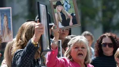 Lori Schott, una demandante que ha presentado una demanda contra empresas de redes sociales por la muerte de su hija, sostiene una fotografía mientras habla con los reporteros a las afueras del Tribunal Superior de Los Ángeles el 25 de marzo de 2026, en Los Ángeles, California.