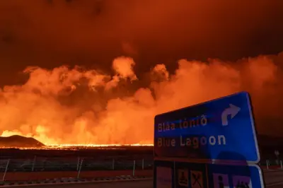 A road sign for Blue Lagoon with flames in background 