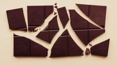 Bej bir arka plan üzerinde parçalara ayrılmış bir bitter çikolata